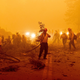 Firefighters battling the Dixie Fire clear Highway 89 after a burned tree fell across the roadway in Plumas County. August 6, 2021